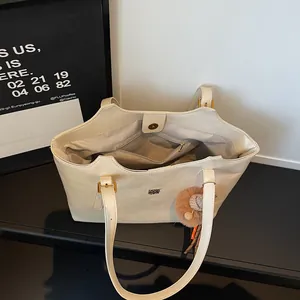 Sac cabas minimaliste en similicuir beige avec grande capacité et accessoire boule peluche