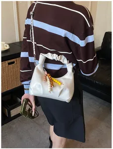 Detailansicht der weißen Halbmond-Tasche mit Falten Griff und bunten Holzperlen