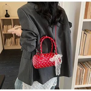 Polka dot cylinder bag in red patent leather with lace bow and pearl chain details