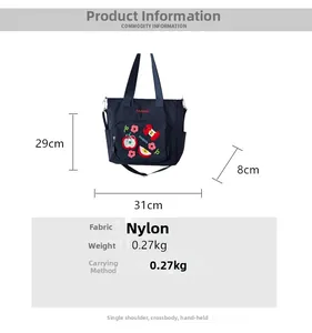 Détail du sac cabas en nylon bleu marine avec broderie pomme et bandoulière réglable incluse