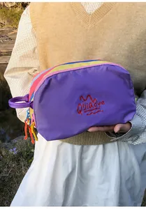 Outdoor macro view of colorful nylon travel toiletry bag with zipper and embroidery