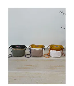 Detailed view of color-block nylon bucket bags with woven rope straps in three color options