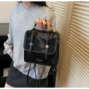 Detail of black marble textured synthetic leather backpack with metal rivets and handle