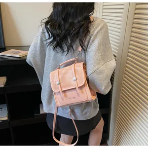 Detail of pink mini backpack showing versatile carrying straps and premium mixed leather texture