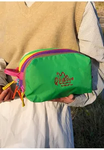 Detail view of multi-layer colorful nylon toiletry bag with textured fabric and hand strap