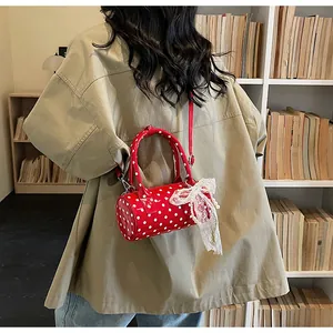 Red retro polka dot barrel bag with lace bow and pearl charm shown on model