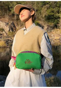 Detail of multi-layer waterproof nylon pouch with vibrant zippers and embroidered logo