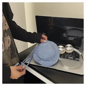 Dettaglio mini pochette in denim a forma di cappello con laccetto da trasporto