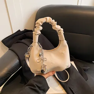 Beige floral embroidered cloud crossbody bag with stylish ruched handle and metal charm
