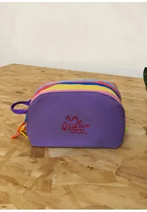 Detailed view of colorful patchwork nylon toiletry bag with zip closure and handle