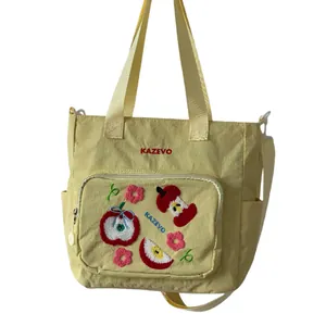 Sac fourre-tout jaune en toile avec broderie pomme et bandoulière réglable