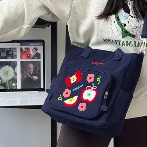 Sac bandoulière bleu marine avec broderie pomme et poches pratiques pour étudiants