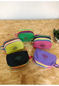 Detail showing five colorful nylon toiletry bags with zippers and side handles