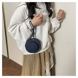 Dettaglio mini custodia a cappello da pescatore in denim con cordino intrecciato al polso