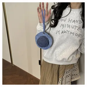 Dettaglio mini portamonete a forma di cappello in denim con laccetto blu per borsa