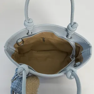 Sac seau rétro bleu clair avec poignée nouée et détails de la poche intérieure zippée