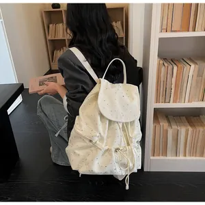 Vue détaillée d'un sac à dos en toile blanche avec motif d'étoiles dans une bibliothèque