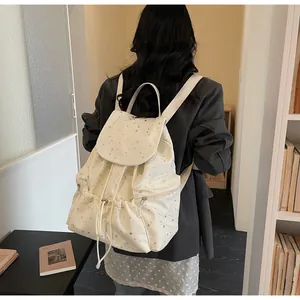 Détail du sac à dos cordon blanc cassé avec imprimé étoiles et poches zippées latérales