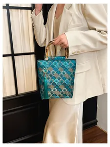 Close-up of green fan pattern jacquard fabric with bamboo handle and silk tassel detail