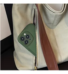 Detail shot of beige tote bag with functional exterior zipper pocket holding a phone
