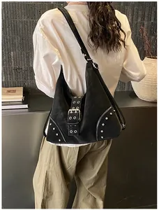 Detailed close-up of retro black studded shoulder bag with metallic buckle and rivets