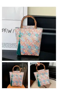 Detail of Chinese style jacquard tote with bamboo handle and blue tassel charm