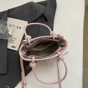 Borsa a secchiello rosa in ecopelle con manico a nodo e catena di perle vista dall'alto