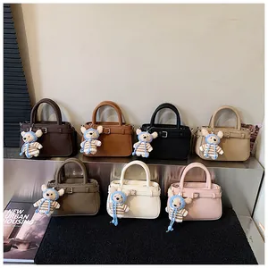 Collection of seven textured PU leather handbags with cute bear charms in varied colors