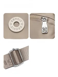 Detail view of the metal logo plaque and premium smooth zippers on the beige nylon bag