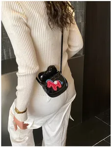 Detail van mini gewatteerde crossbodytas met 3D-strik en abstract paardborduurwerk