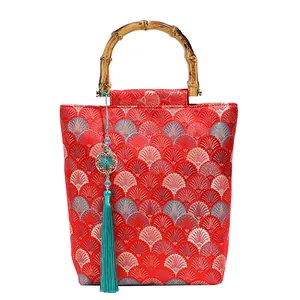 Retro Chinese jacquard handbag with bamboo handle, red floral pattern and green tassel