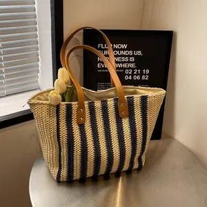 Woven straw tote bag with navy stripes, leather handles and spacious interior design