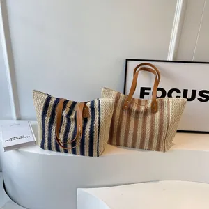 Fashionable large woven tote bags in navy and brown stripes with brown faux leather handles