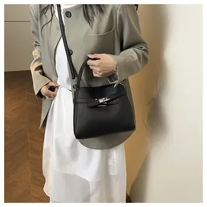Detail of black lychee grain leather bucket bag with silver buckle and shoulder strap