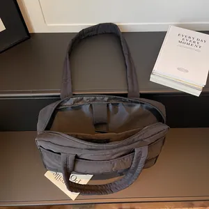Black quilted laptop tote bag with dual compartments and padded laptop sleeve
