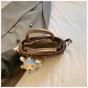 Brown PU leather crossbody bag with a cute bear plush pendant and zipper closure