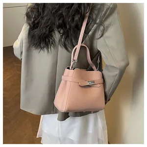 Pink lychee grain leather bucket bag with silver twist lock shown on a model