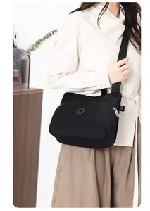 Detail of waterproof black nylon crossbody bag with wide strap and zip pocket