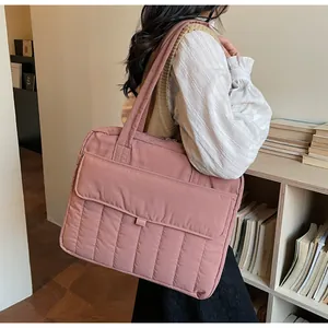 Pink quilted shoulder bag with front flap pocket shown in a library setting