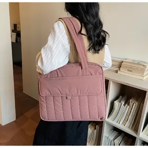 Detailed view of dust pink quilted tote bag showing large capacity and vertical stitching