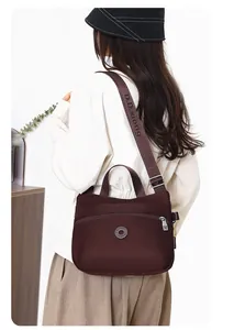 Detail of burgundy nylon crossbody bag with wide logo-printed adjustable strap