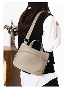 Khaki nylon crossbody bag with wide letter-printed strap shown on model for daily commute