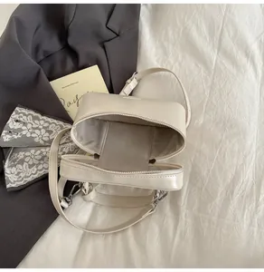 Vue de dessus d'un sac carré beige montrant la doublure chevrons et la fermeture éclair