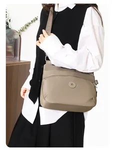 Detail of khaki crossbody bag with wide nylon strap and matte fabric texture