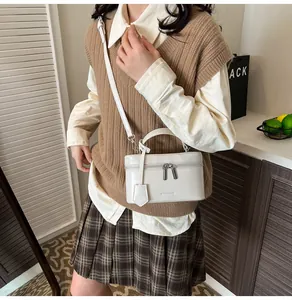 Détail du sac à main carré blanc avec finition brillante et bandoulière réglable