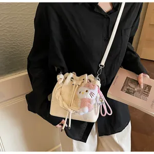 Close-up of cream bucket bag with star embossing and woven handle on a model