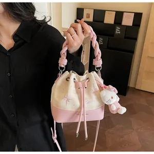 Detailed shot of pink bucket bag with plaid fabric, star embroidery and plush charm