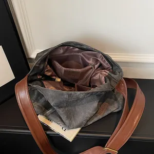 Large gray canvas tote bag with brown leather straps and spacious satin interior
