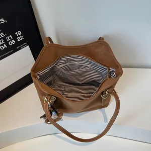 Vintage brown tote bag with striped lining, interior zip pocket and cute bear charm