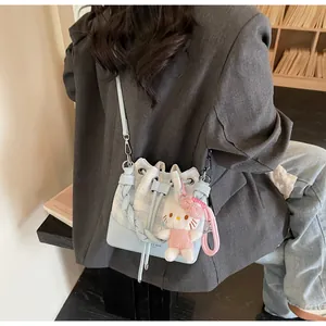 Detail of blue plaid bucket bag with adjustable strap and cute plush charm on mannequin